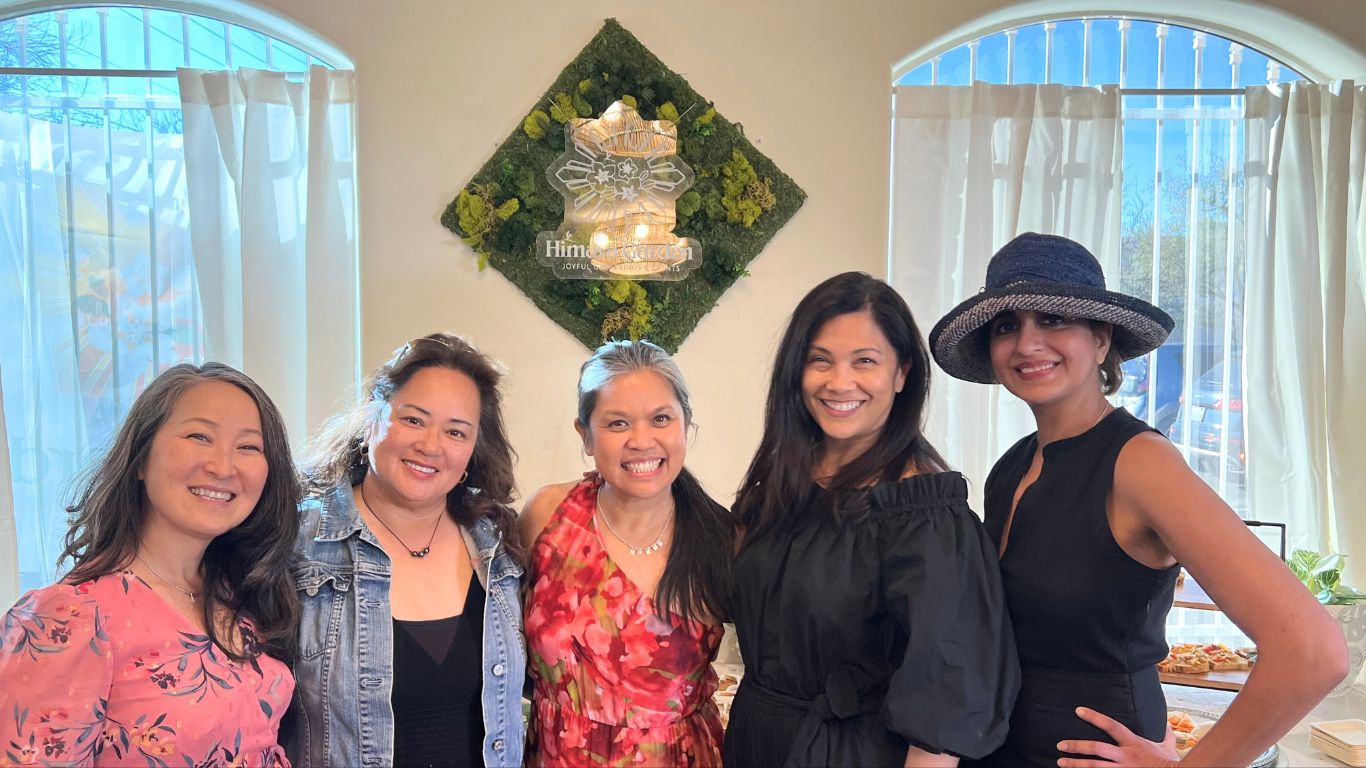 Five smiling women stand together indoors, with a "Himaya Garden" sign behind them.